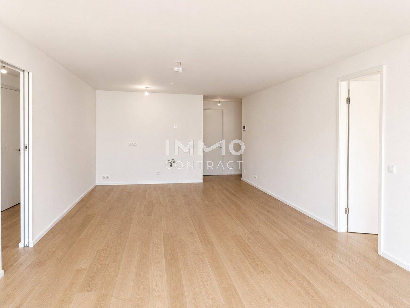 Offener Wohnbereich mit hellem Holzboden und Zugang zu weiteren Räumen der Wohnung.