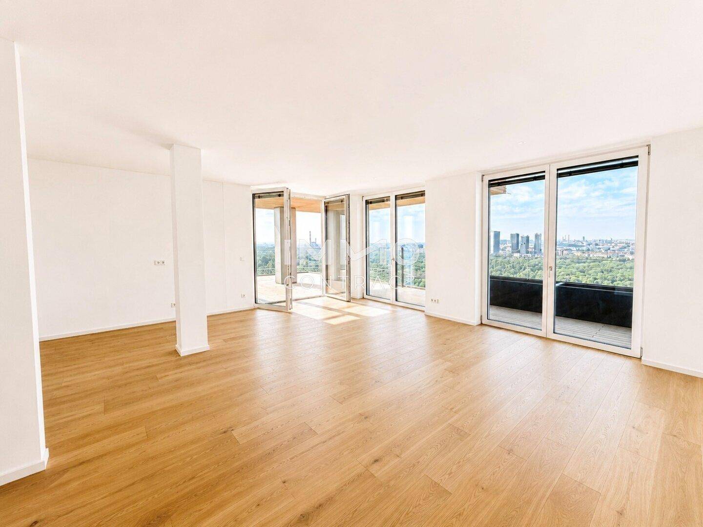 Großer, heller Wohnraum mit Eichenparkett und bodentiefen Fenstern, die einen Panoramablick ermöglichen.