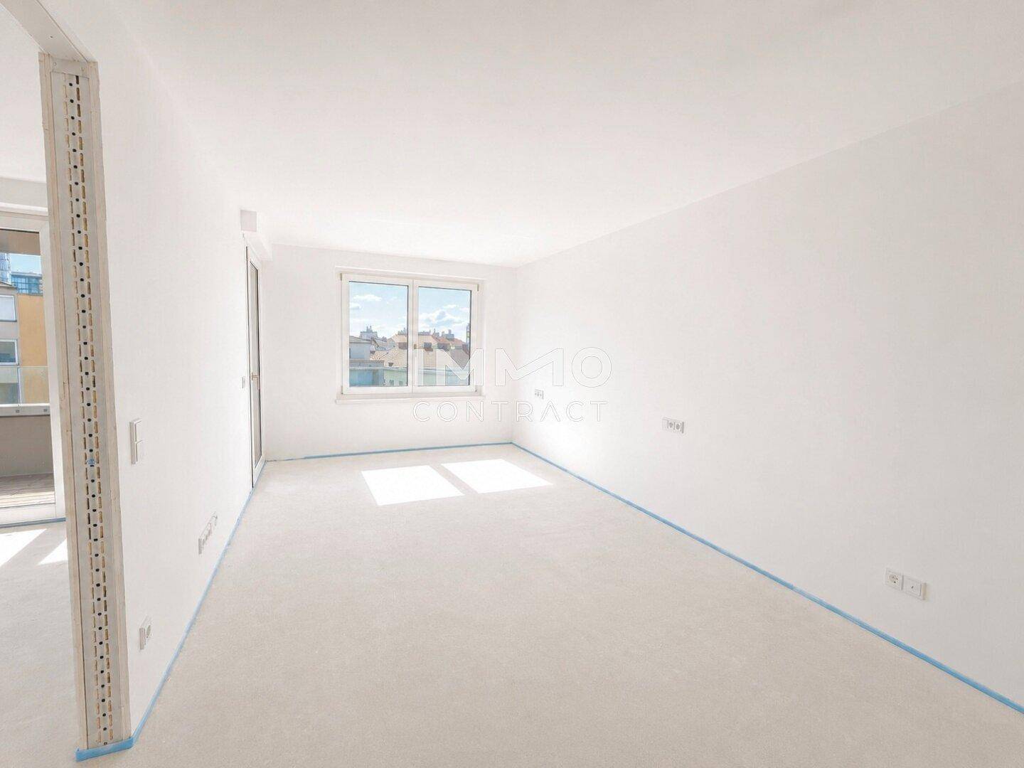 Helles Schlafzimmer mit weiß gestrichenen Wänden und einem Fenster, das Tageslicht hereinlässt.