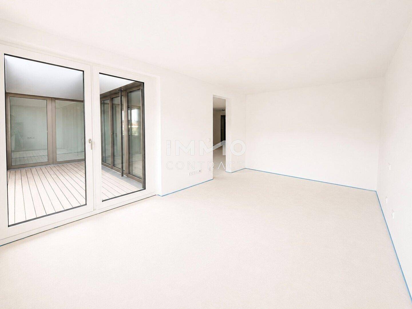 Geräumiger, leerer Raum mit großen Glasfronten, bereit für den Innenausbau.