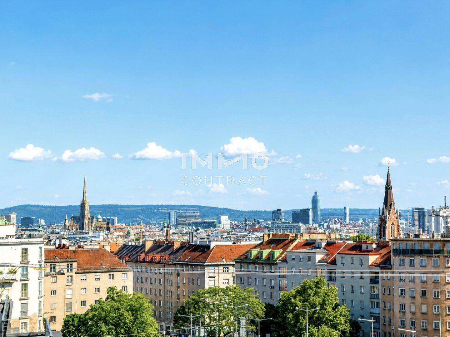 Panoramablick über die Stadt mit historischen Kirchtürmen und modernen Gebäuden im Hintergrund.