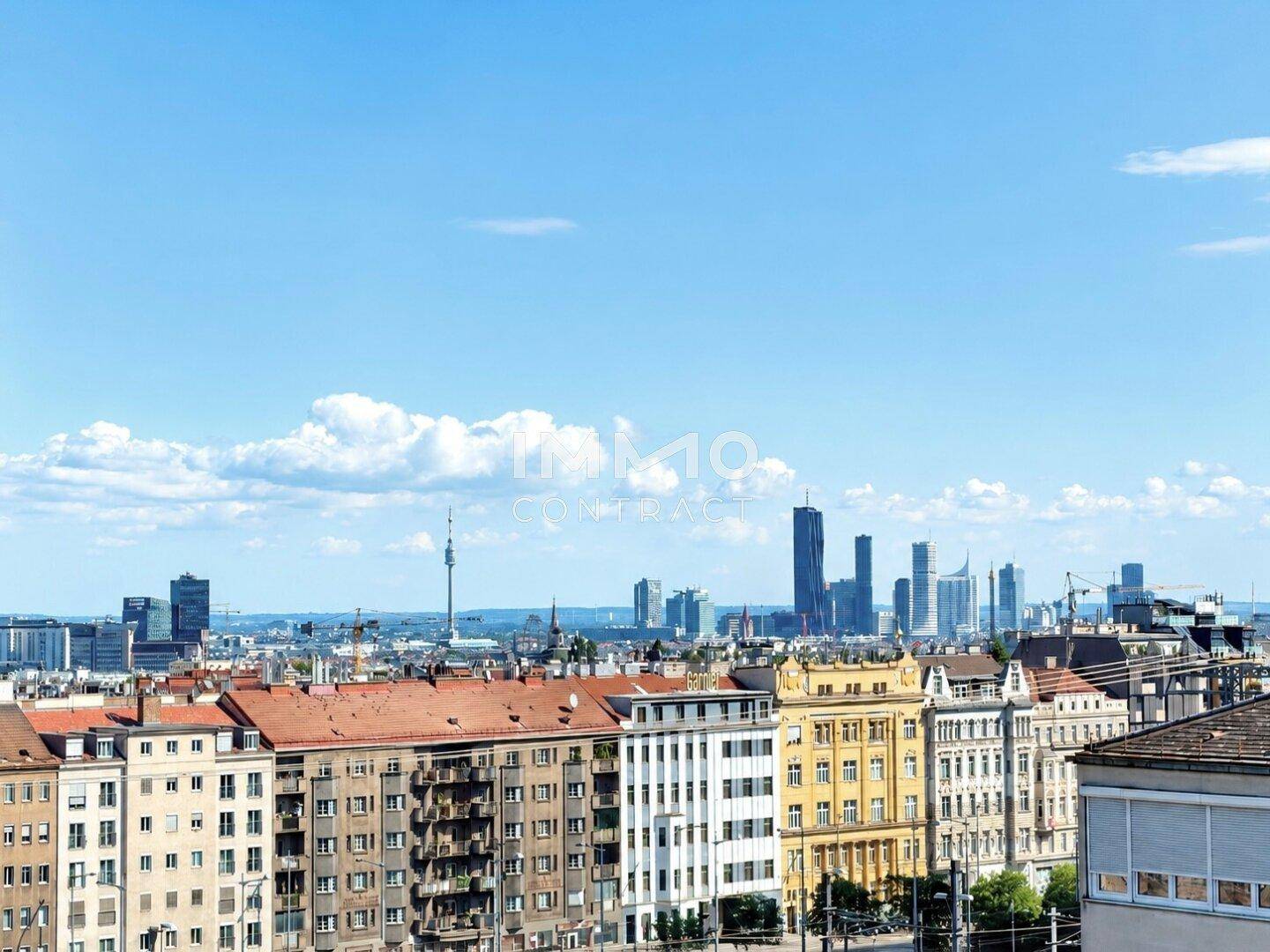 Weitläufiger Stadtblick mit modernen Hochhäusern und historischer Architektur unter blauem Himmel.