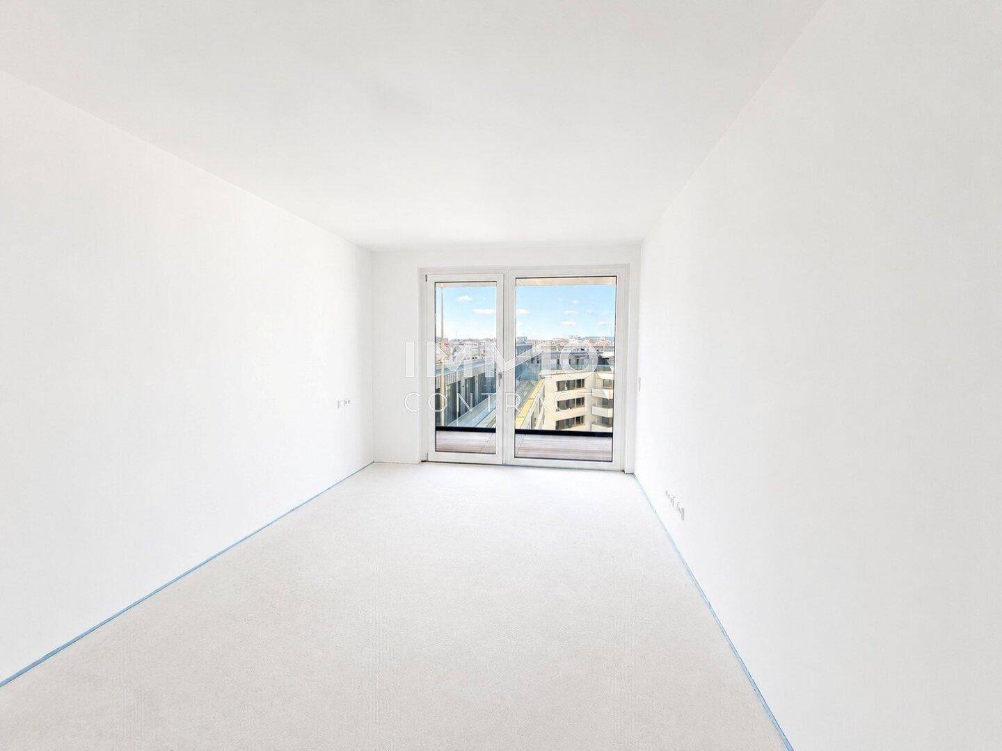 Leeres Zimmer mit großem Fenster und Blick auf die Stadt, bereit zur individuellen Gestaltung.