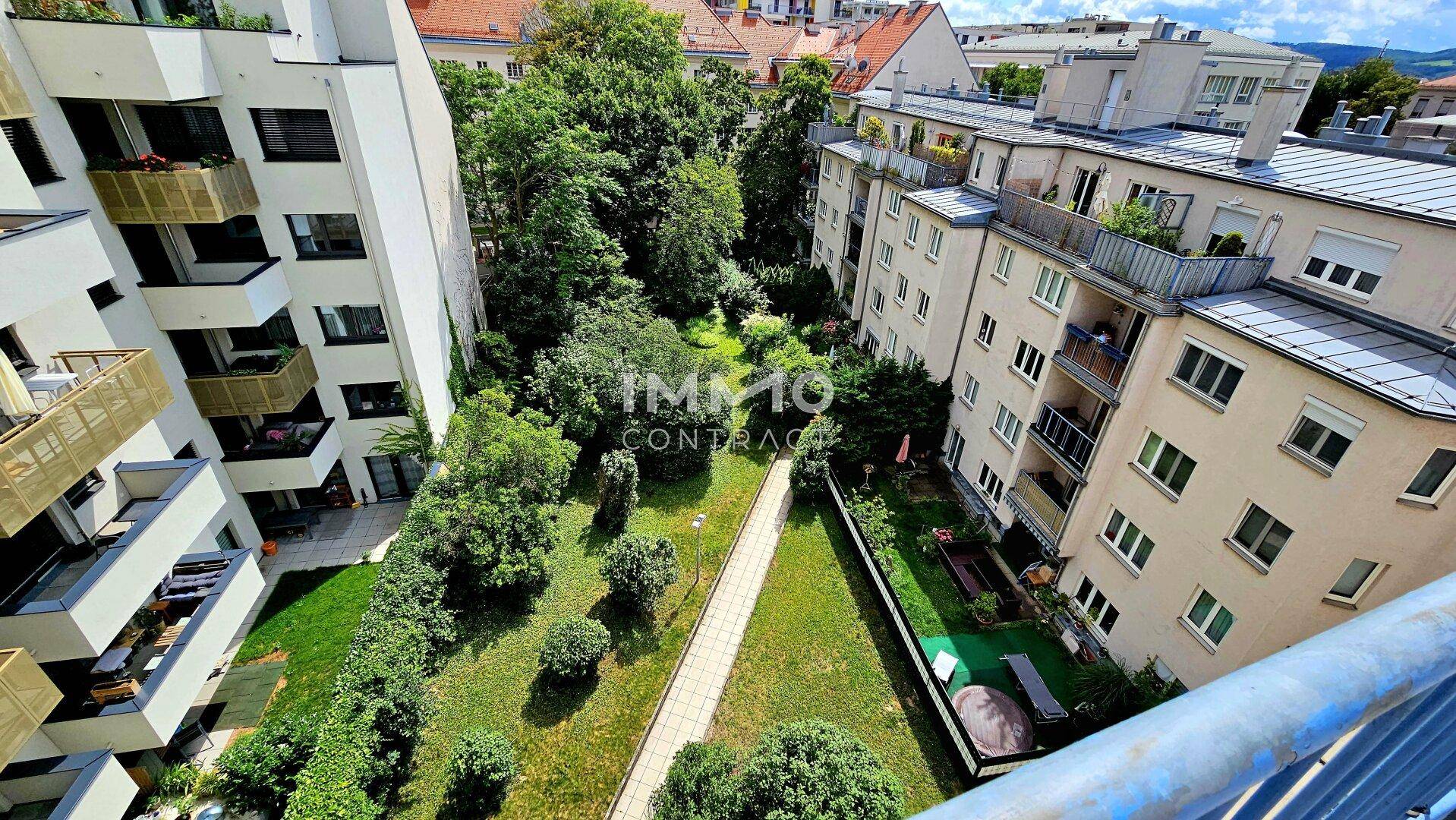 Blick auf den grünen Innenhof und die umliegenden Wohngebäude von oben.