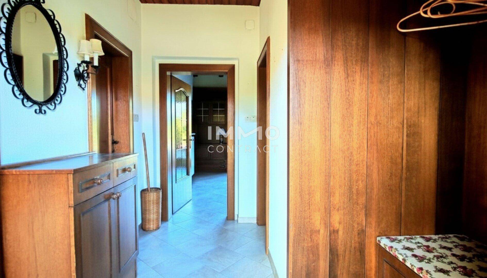 Gemütlicher Flur mit Holzvertäfelung, Spiegel und einer kleinen Kommode.