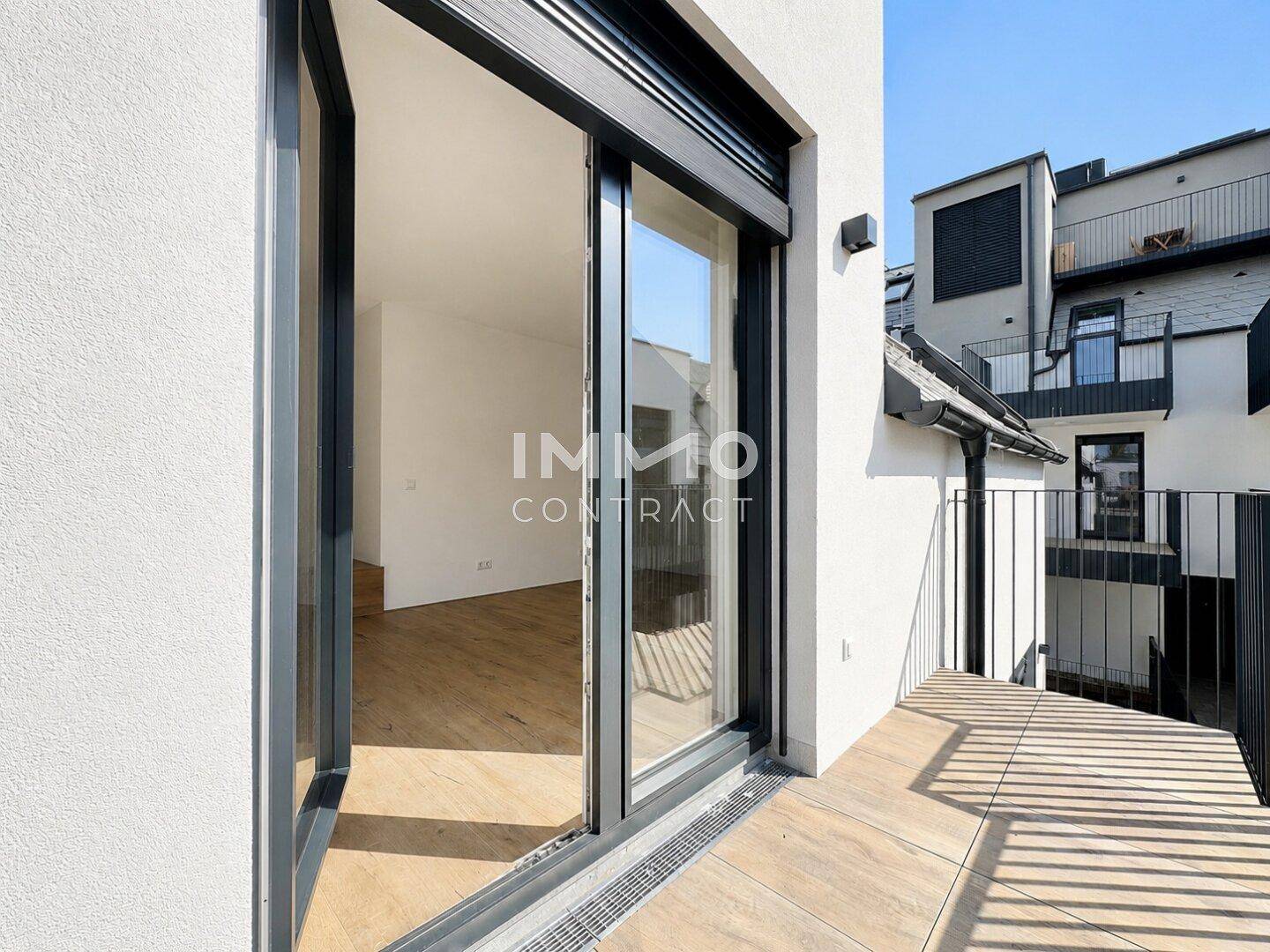Kleiner Balkon mit Fliesenboden und Blick auf die umliegenden Gebäude.