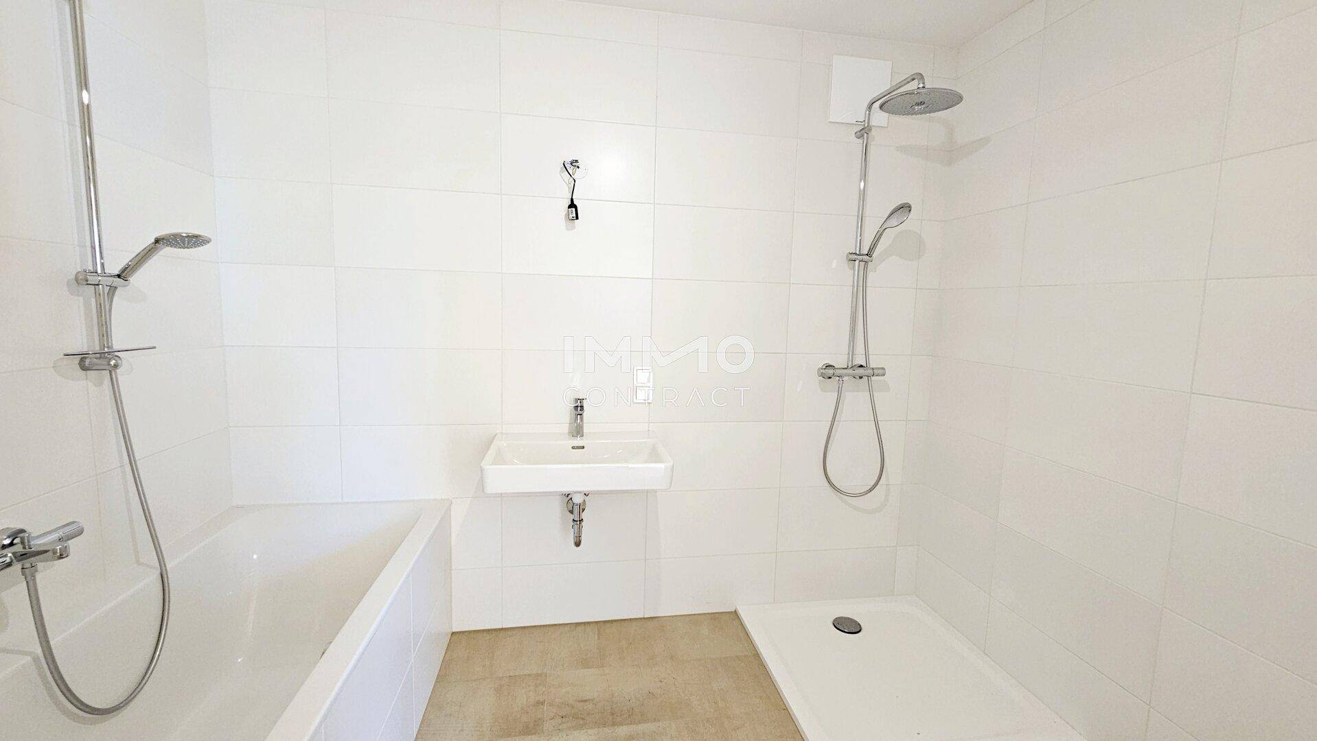 Modernes Badezimmer mit weißen Fliesen, Badewanne, Dusche und einem einzelnen Waschbecken.