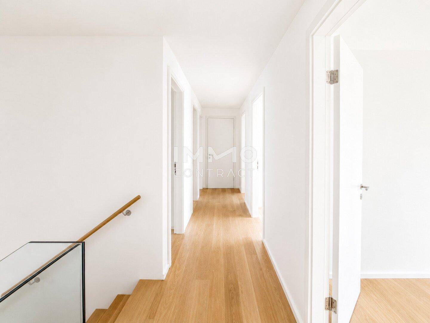 Heller Flur mit Holzboden und Treppe, die zu weiteren Räumen im Obergeschoss führt.