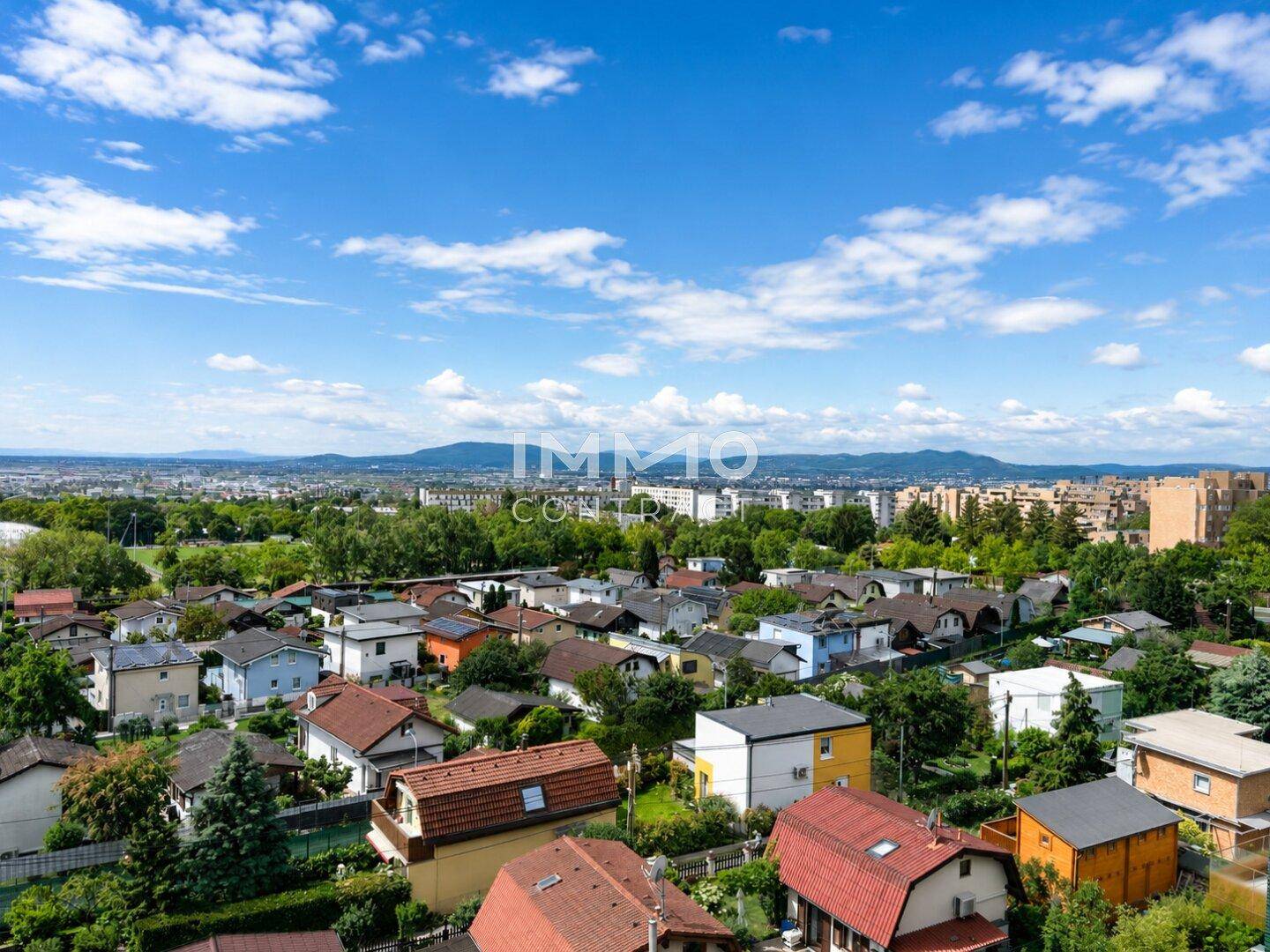 Panoramablick über die Dächer der Stadt und die umliegende grüne Landschaft.