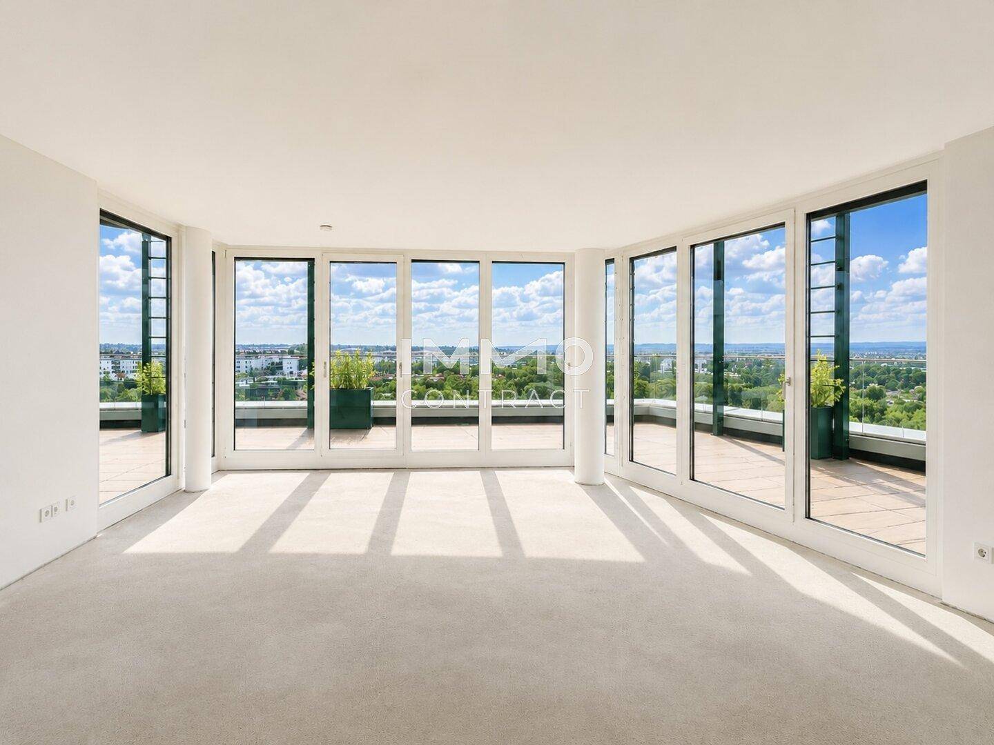 Heller, leerer Raum mit großen Panoramafenstern und Teppichboden, bietet weite Ausblicke ins Grüne.