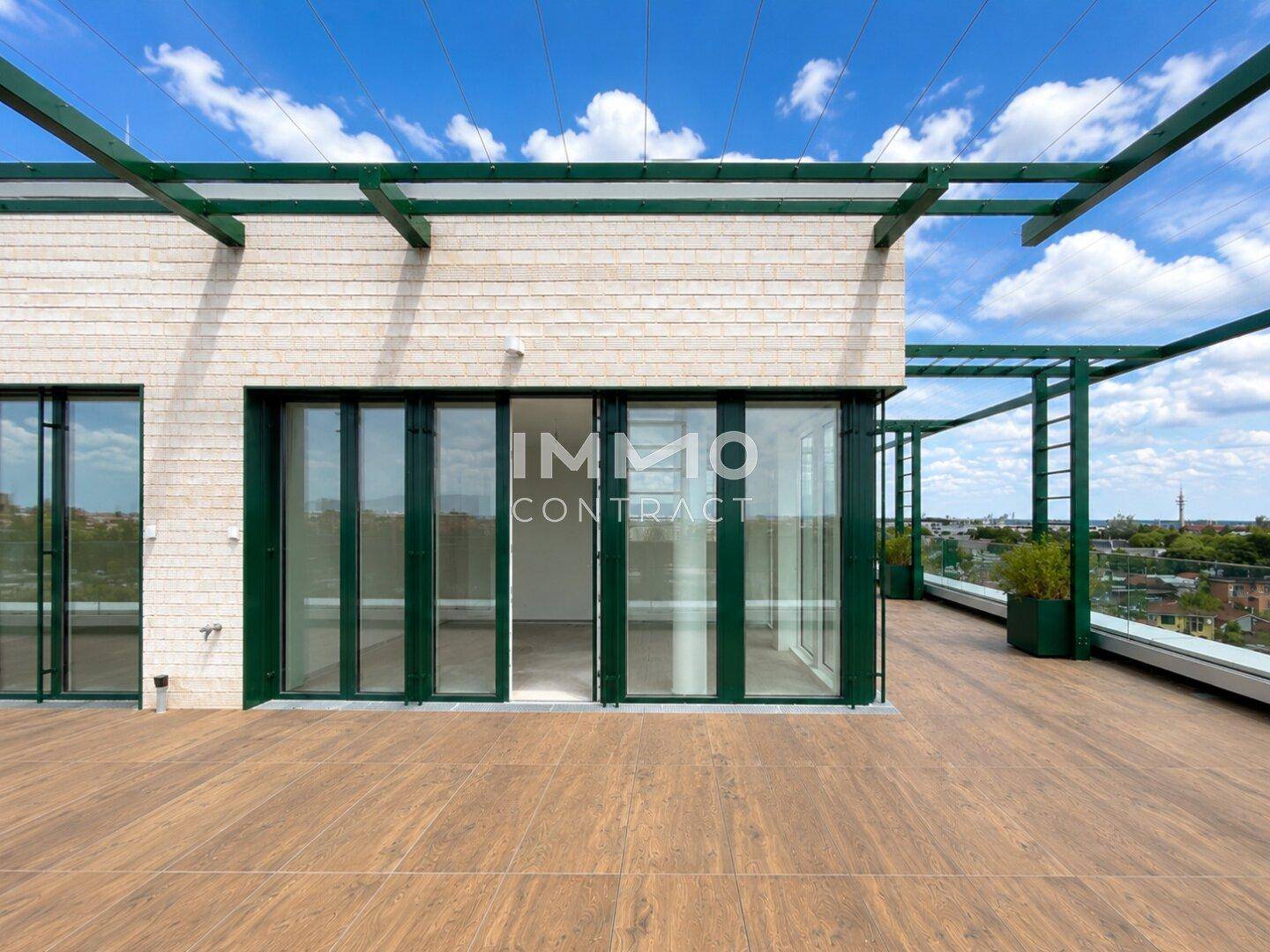 Geräumige Terrasse mit Holzboden und Zugang zu den Innenräumen durch große Glasfronten und Schiebetüren.