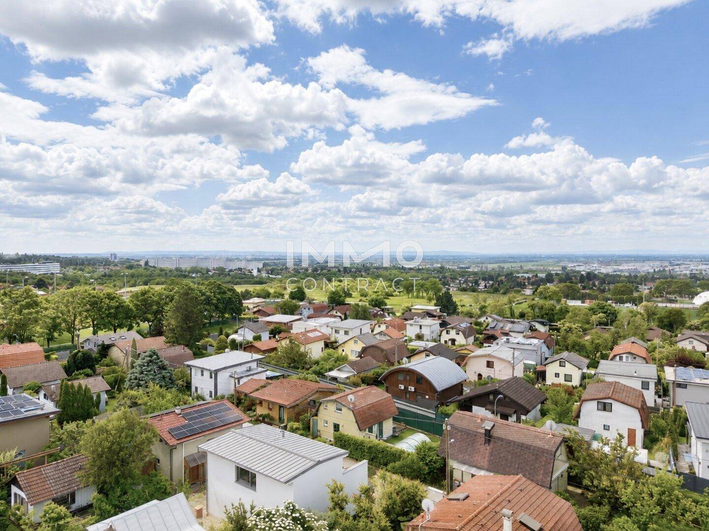 Panoramablick über die Dächer der umliegenden Häuser und die weite Landschaft mit Bergen im Hintergrund.