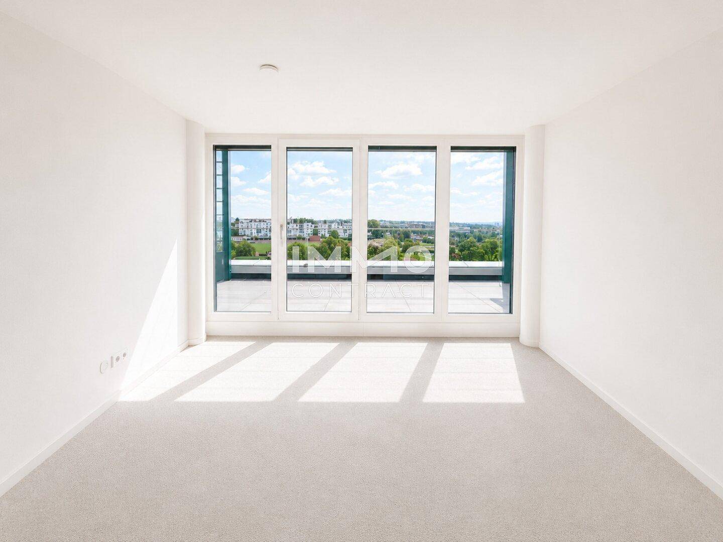 Geräumiger, heller Raum mit Teppichboden und Panoramafenstern, die eine weite Aussicht auf die Umgebung ermöglichen.
