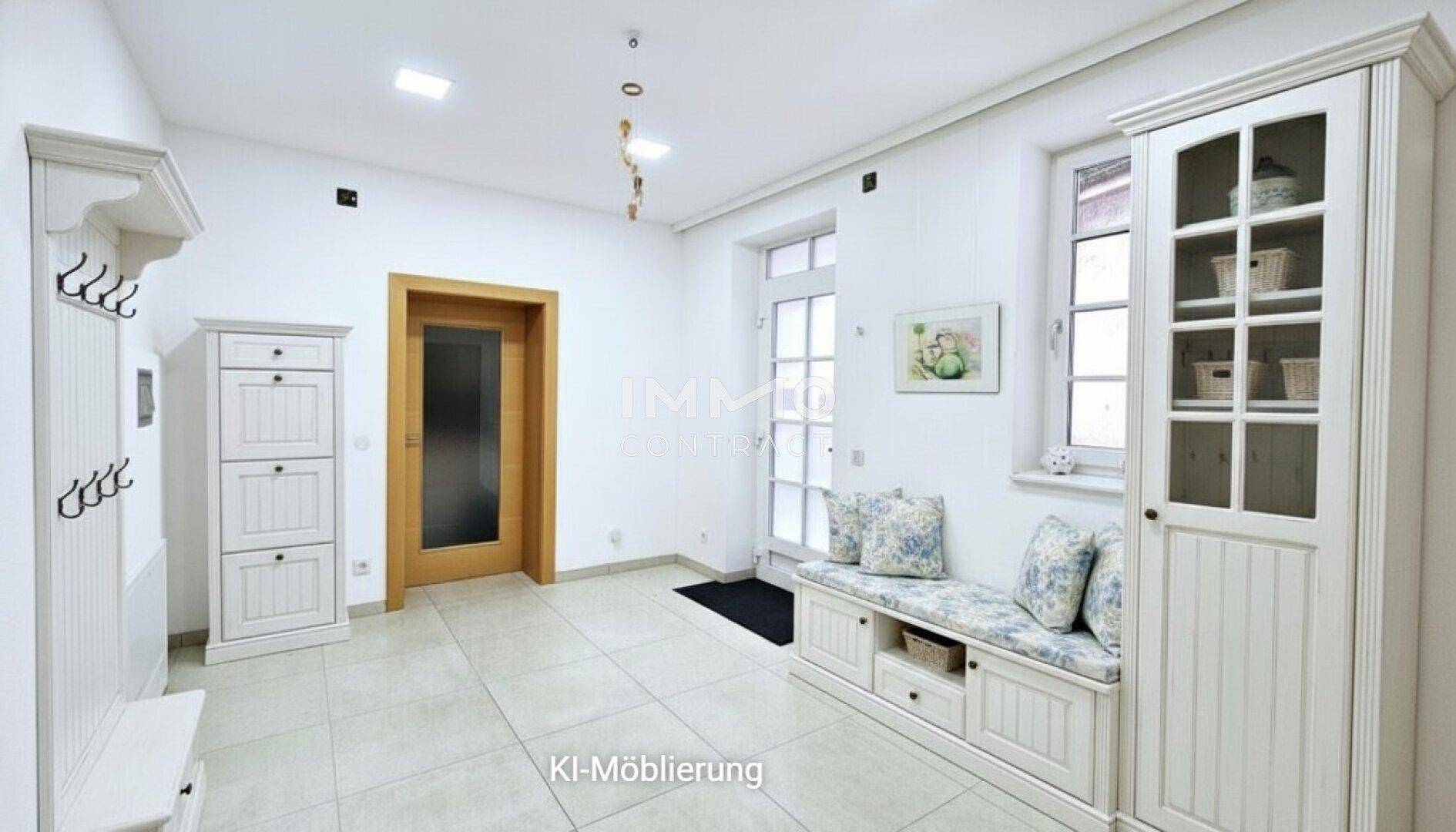 Freundlicher Eingangsbereich mit weißer Garderobe, Sitzbank und Fliesenboden.