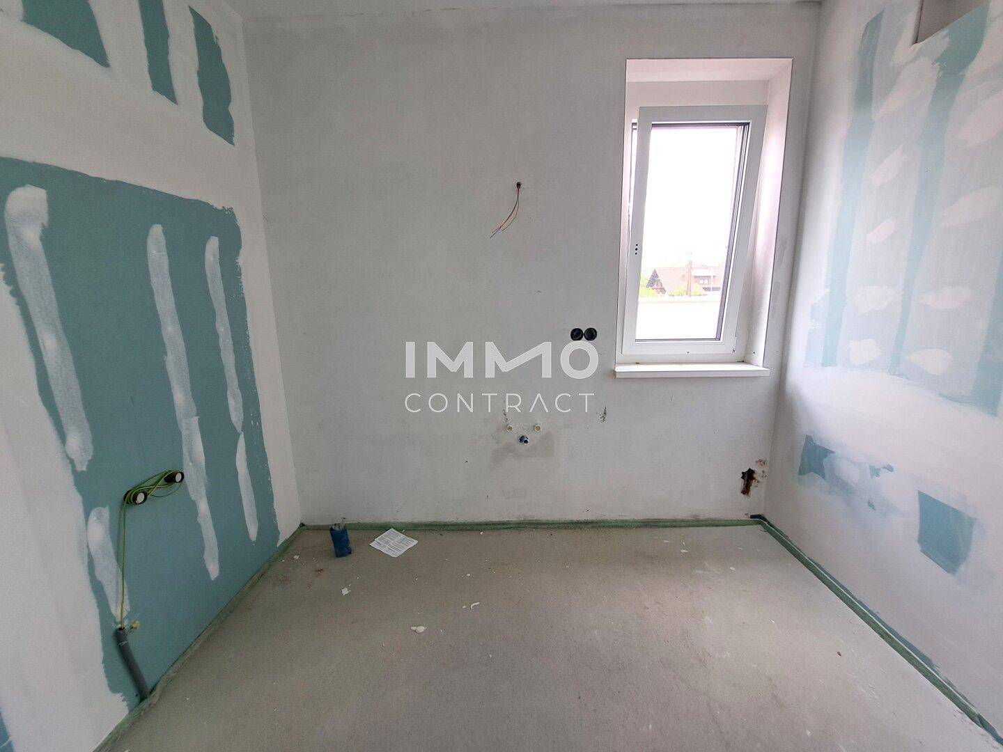 Kleiner Rohbau-Raum mit Fenster und sichtbaren Installationen für Sanitäranlagen.