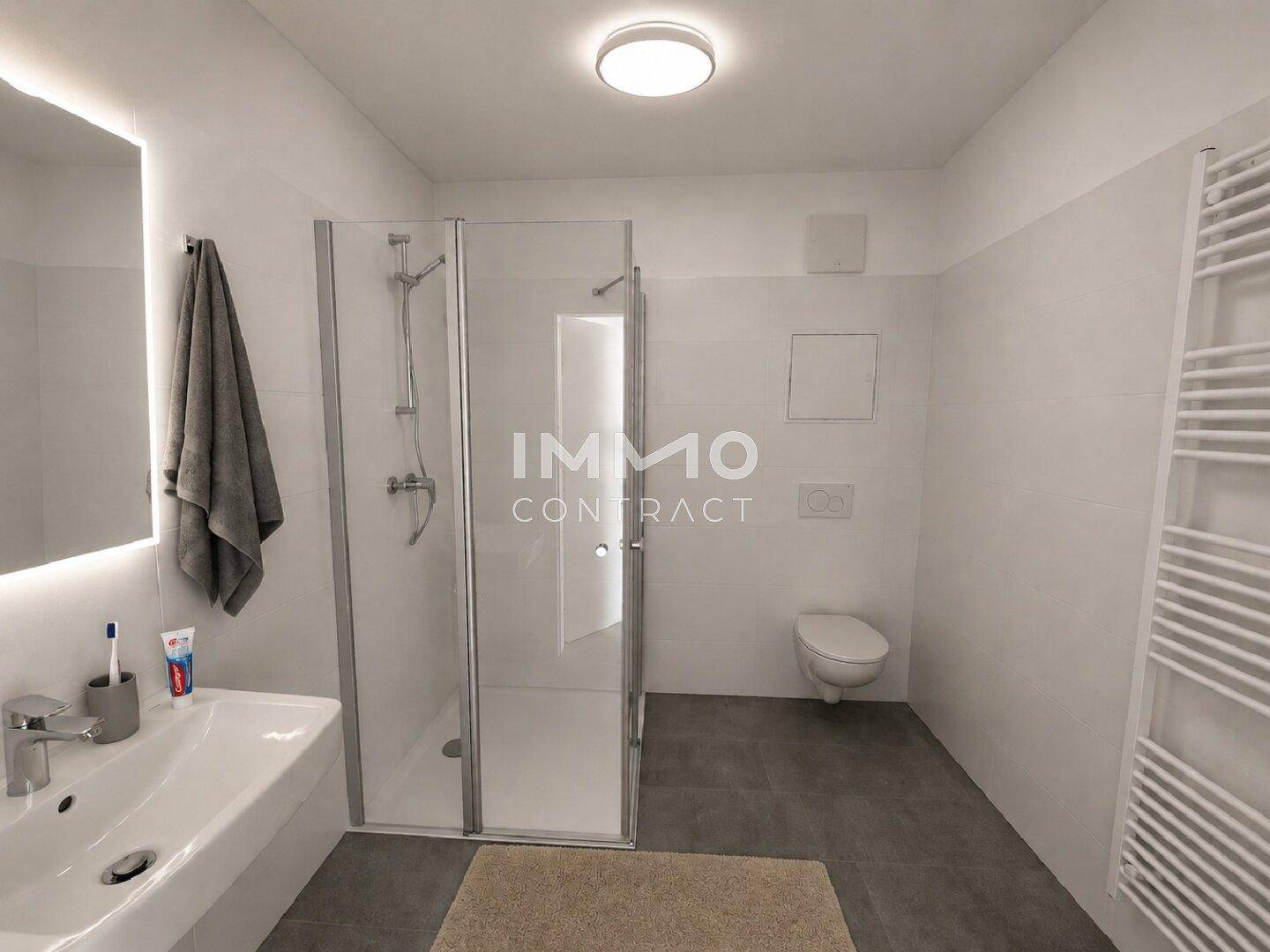 Modernes Badezimmer mit ebenerdiger Dusche, Wand-WC und beheiztem Handtuchhalter.