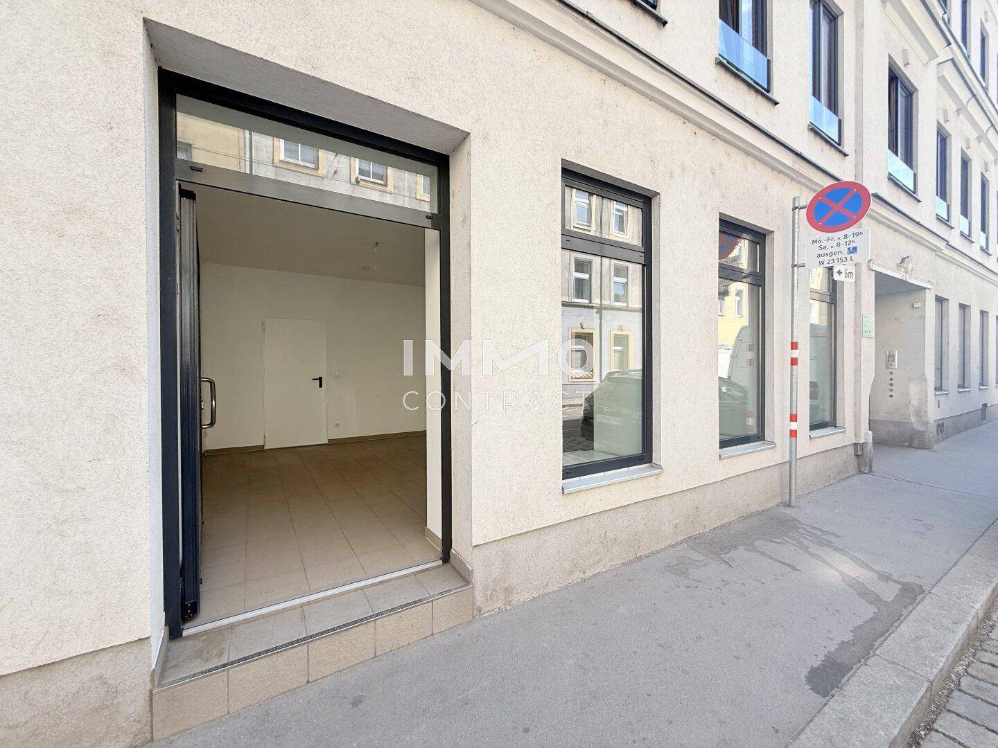 Eingangsbereich eines Geschäfts mit offener Tür und Blick in den Verkaufsraum von der Straße.