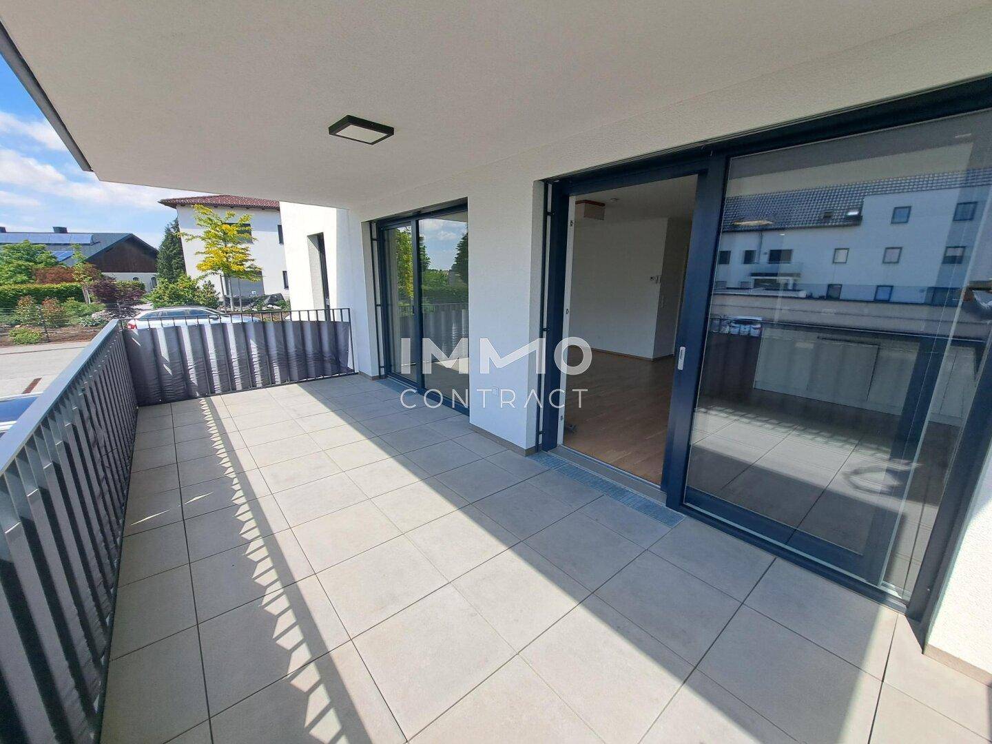 Großer Balkon mit Fliesenboden und Metallgeländer, der viel Platz im Freien bietet.