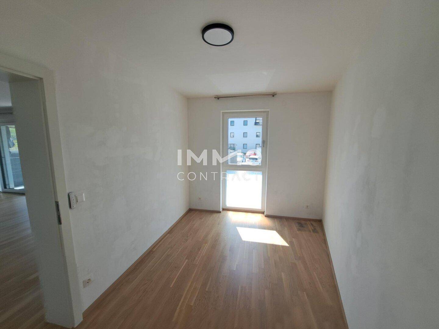 Geräumiges Zimmer mit Holzfußboden und Fenster, das vielseitig genutzt werden kann.