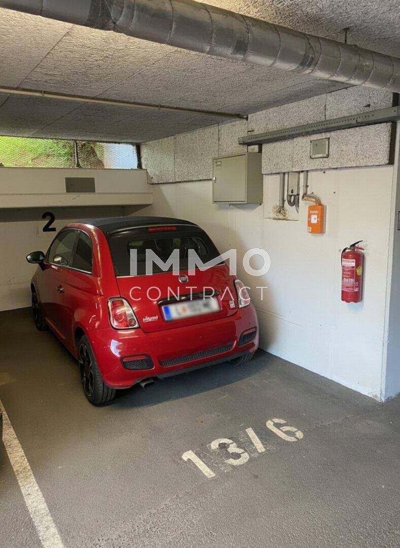 Einzelner Tiefgaragenstellplatz mit rotem Auto, gekennzeichnet durch die Nummer 13/6.