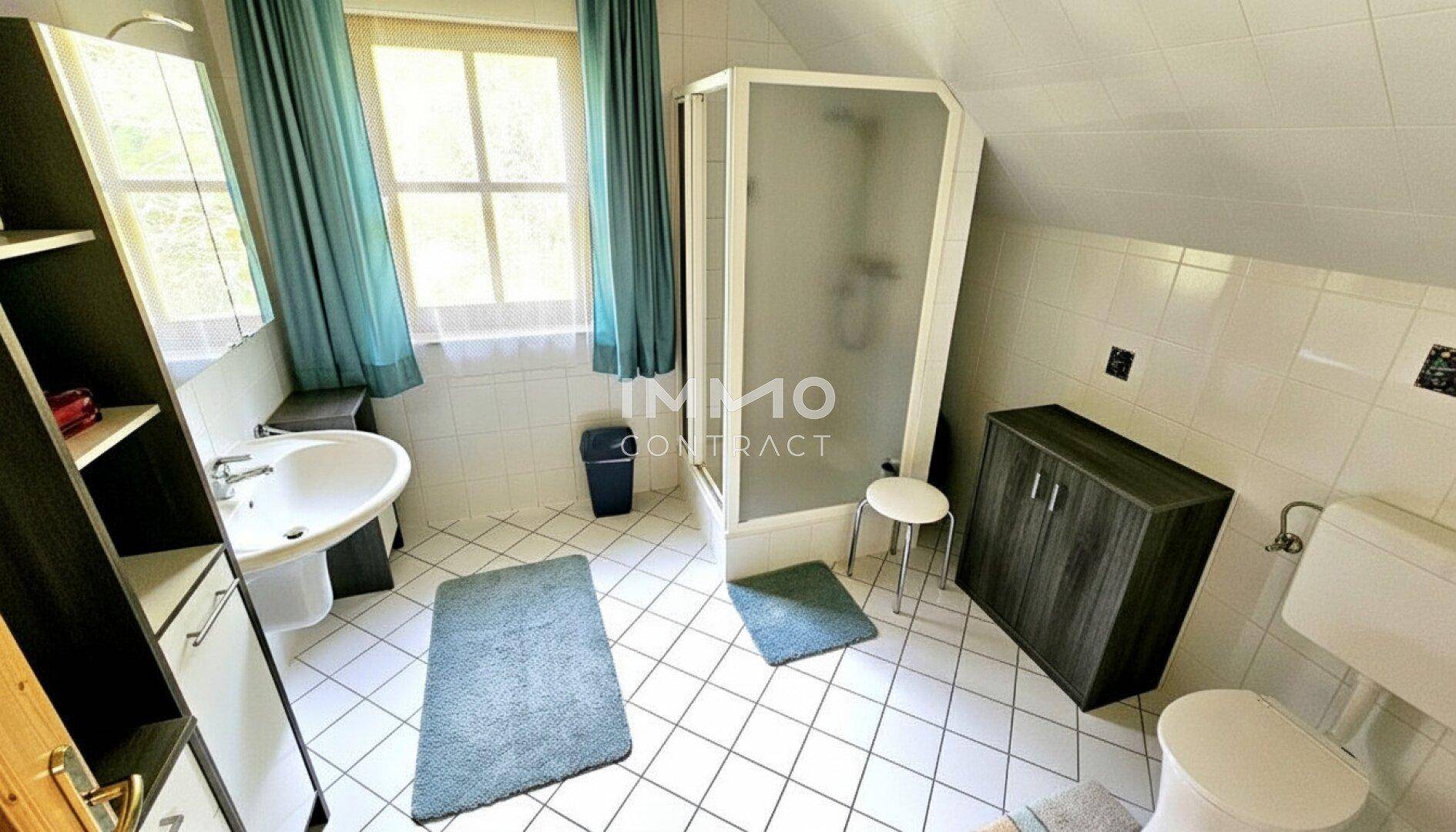 Helles Badezimmer im Dachgeschoss mit Dusche, WC und Fenster.