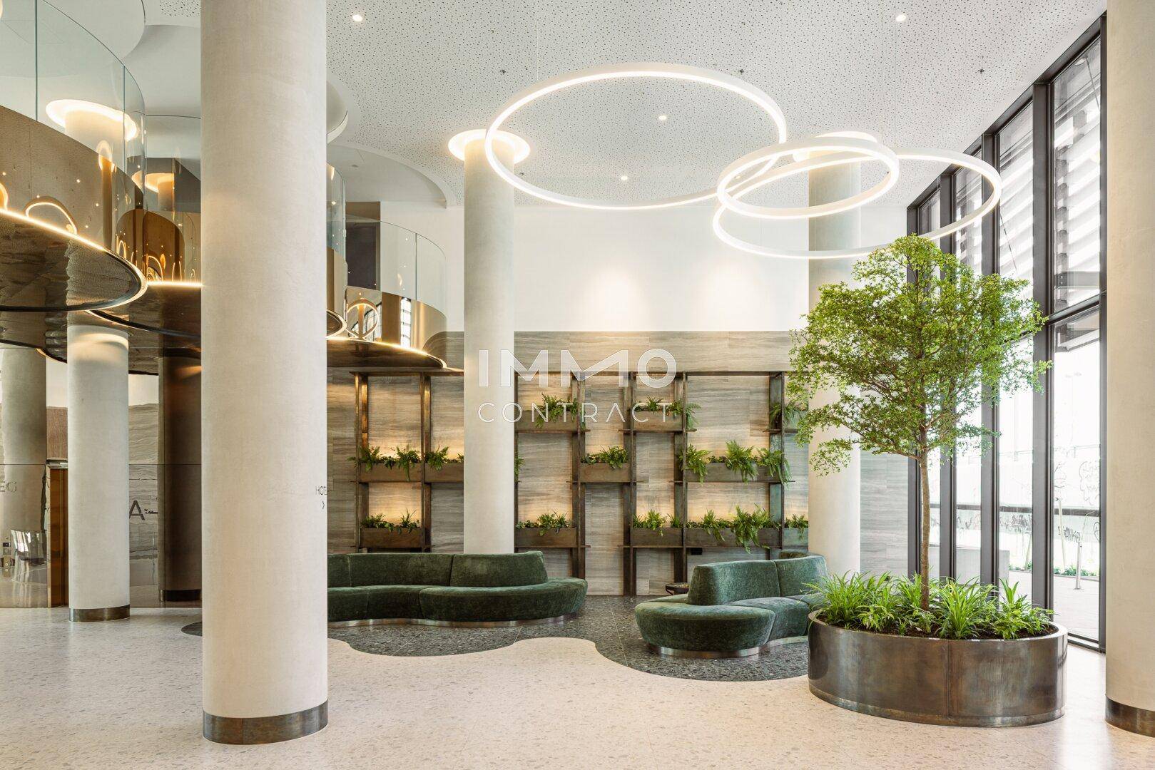 Helle und moderne Lobby mit Pflanzen, bequemen Sitzgelegenheiten und stilvoller Beleuchtung.