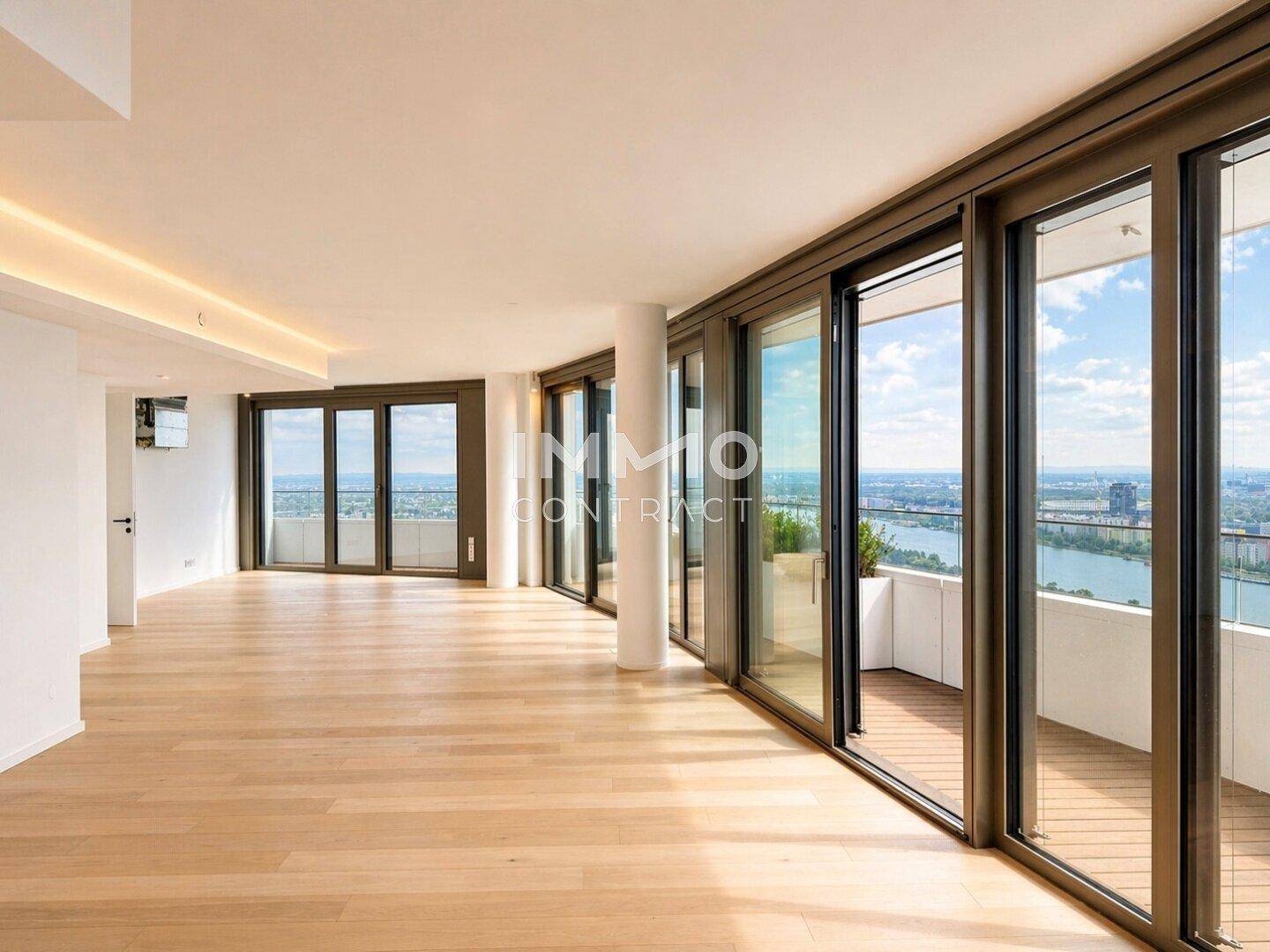 Großer, heller Wohnbereich mit Holzboden und raumhohen Fenstern mit Zugang zum Balkon.