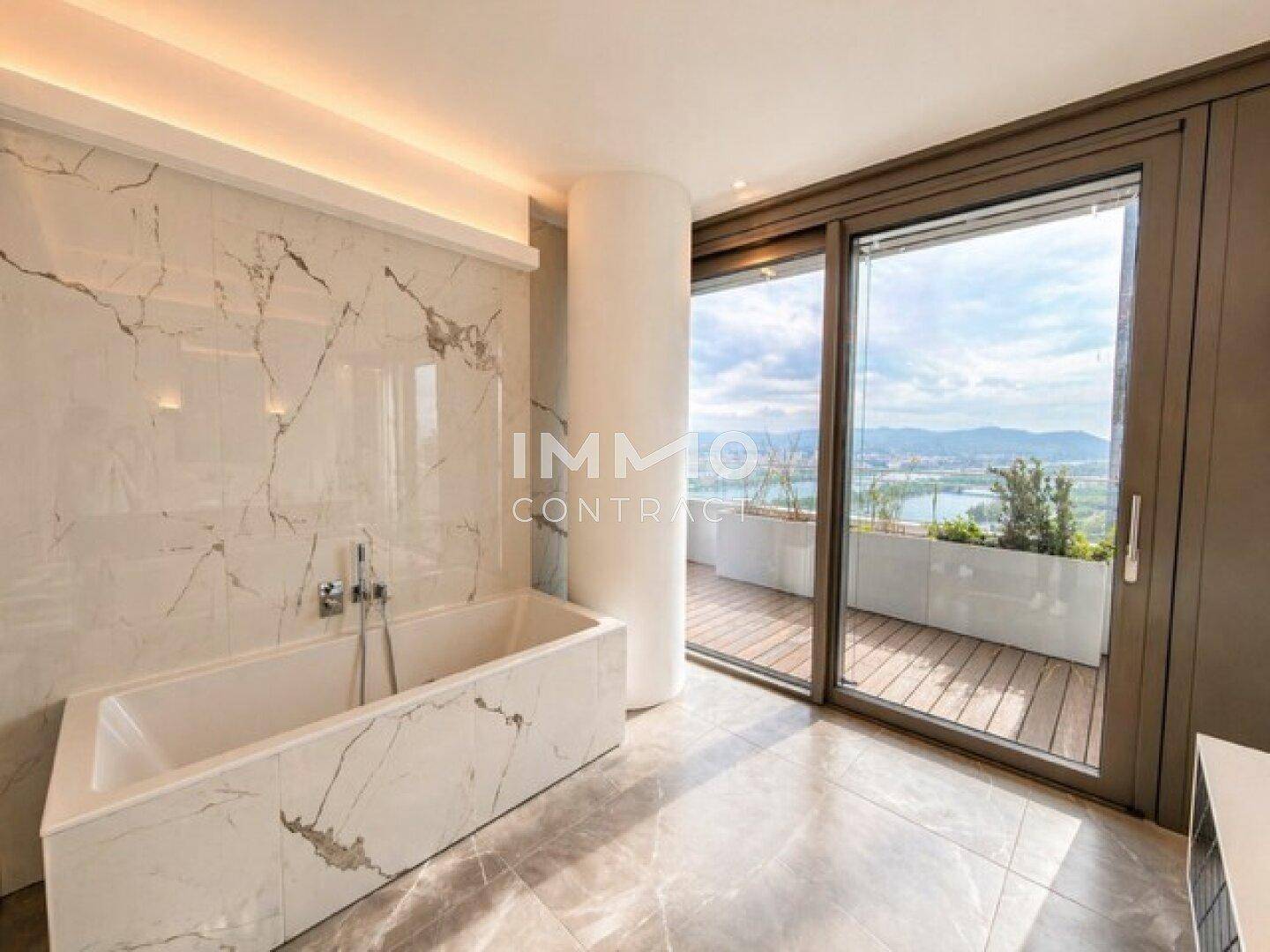Modernes Badezimmer mit Marmorwänden, Badewanne und großem Fenster mit Zugang zum Balkon.