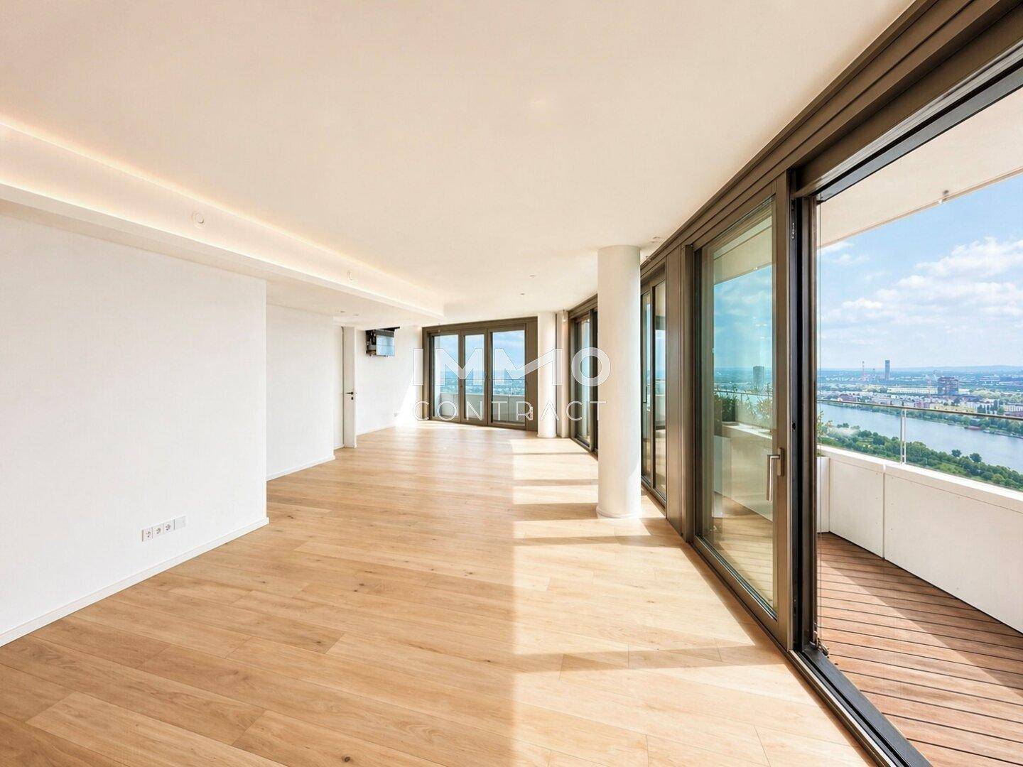 Lichtdurchfluteter Wohnbereich mit Eichenparkett und Panoramafenstern, die auf einen Balkon führen.