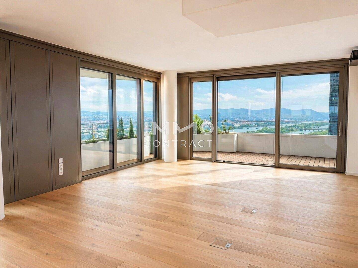 Moderner Wohnbereich mit Holzboden, dunkler Wandverkleidung und Zugang zu einem Balkon.