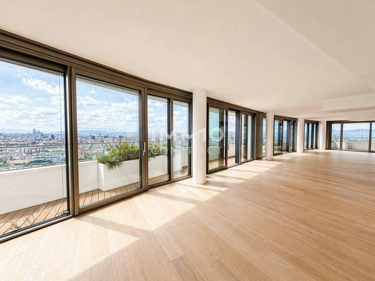 Weitläufiger Wohnbereich mit Holzboden und raumhohen Fenstern, die einen weiten Stadtblick bieten.