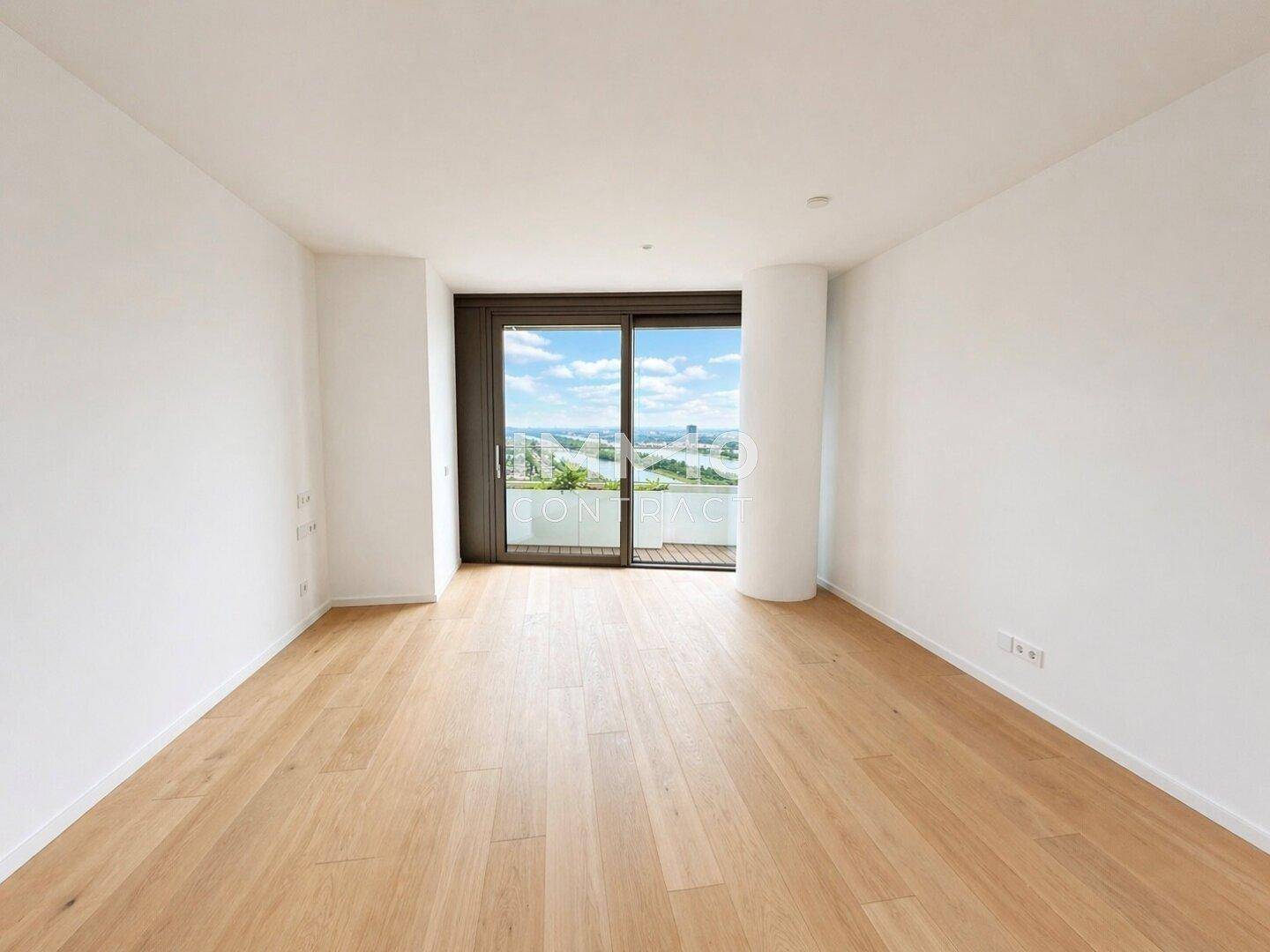 Ruhiges Zimmer mit Holzboden und Schiebetür zum Balkon, bietet einen schönen Ausblick.