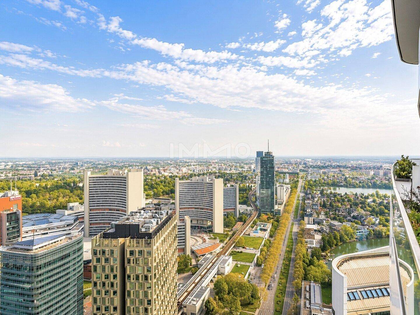 Panoramablick über die Stadt mit modernen Gebäuden und einem Fluss unter blauem Himmel.