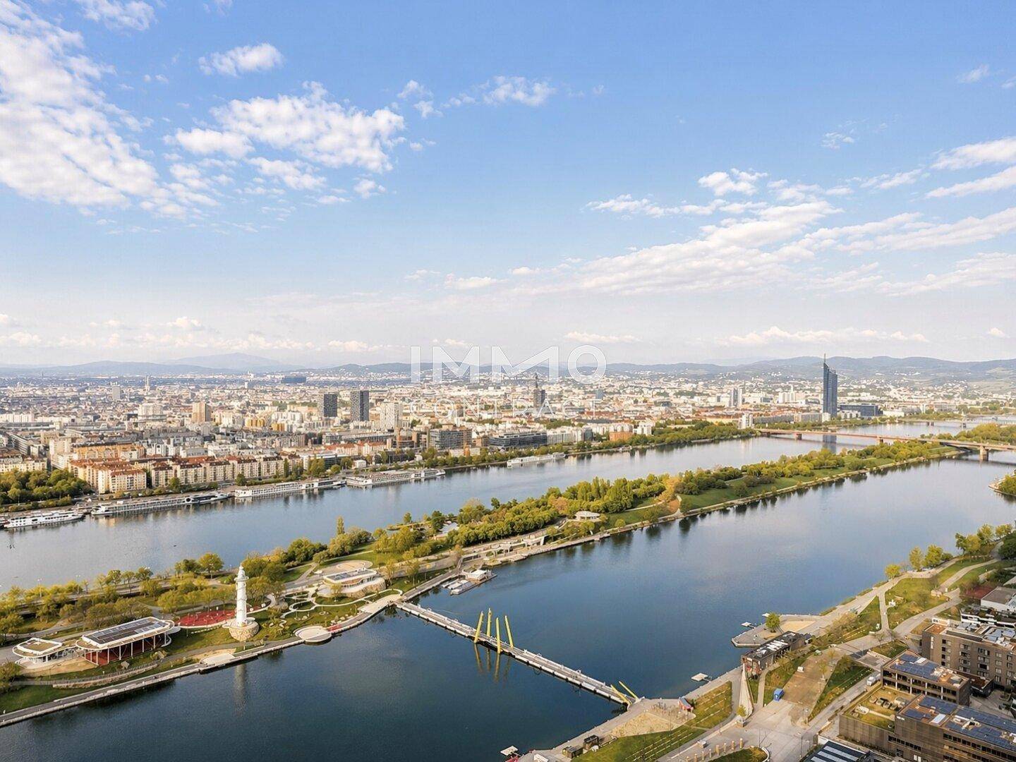 Weitläufiger Blick über die Donau und die Skyline der Stadt an einem sonnigen Tag.