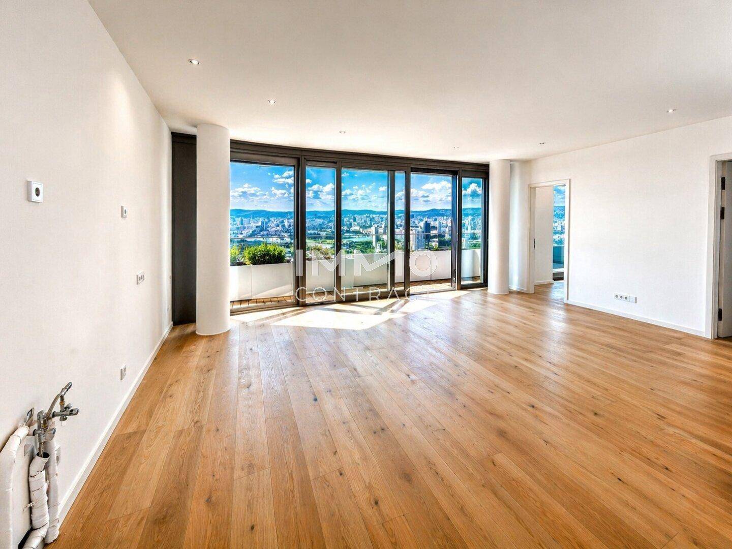 Großzügiges Wohnzimmer mit Holzboden und raumhohen Fenstern, die einen weiten Stadtblick bieten.