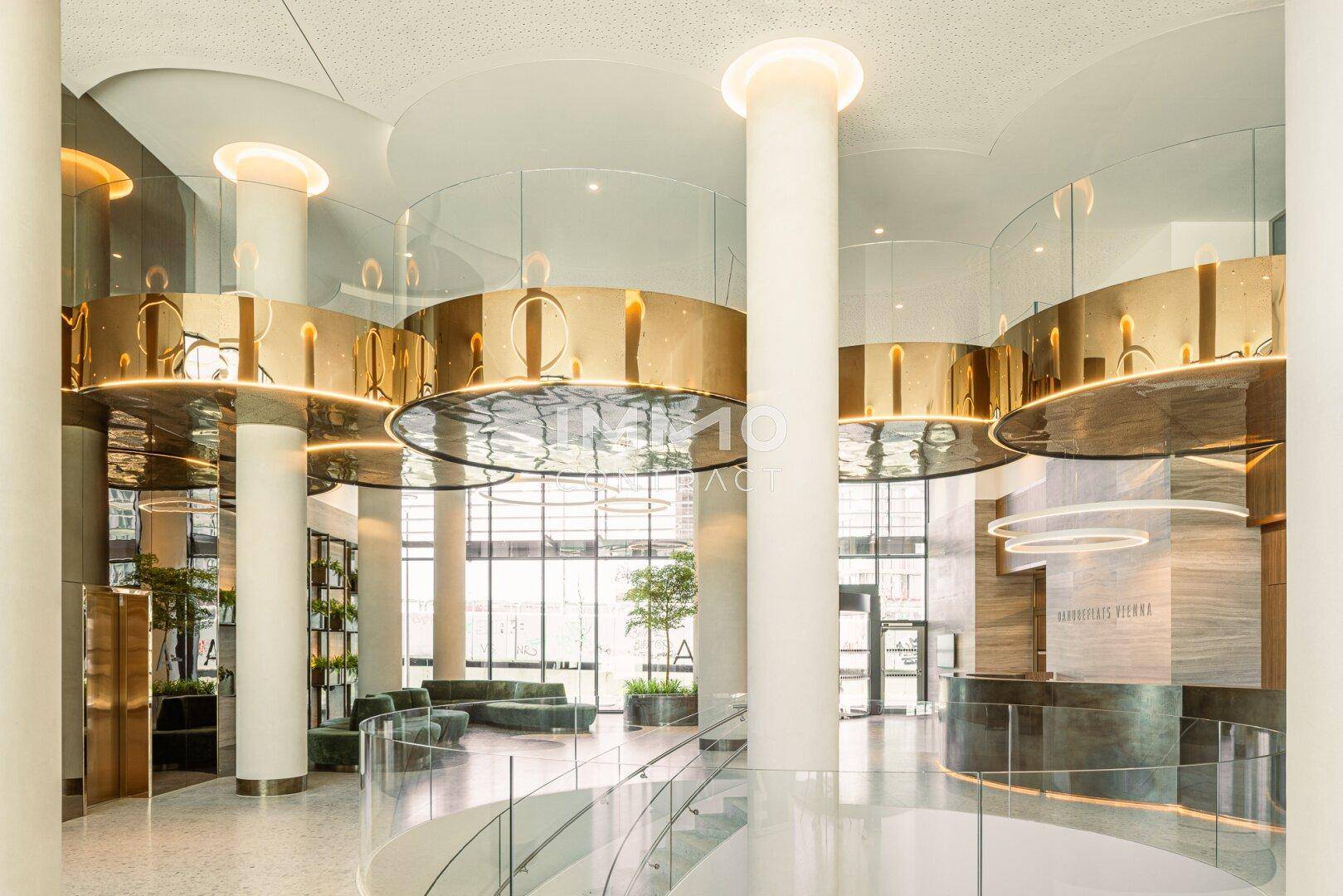 Luxuriöse Lobby mit hohen Säulen, glänzenden Oberflächen und moderner Beleuchtung.
