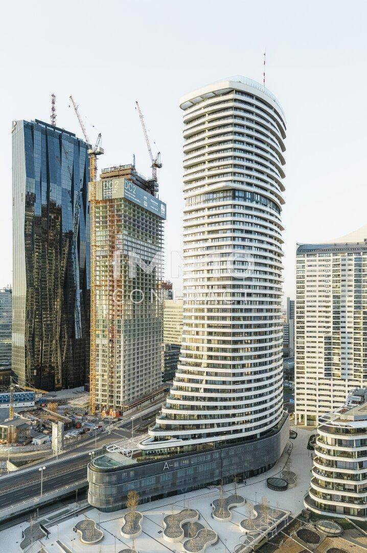Panoramablick auf moderne Hochhäuser und städtische Entwicklung mit Baukränen.