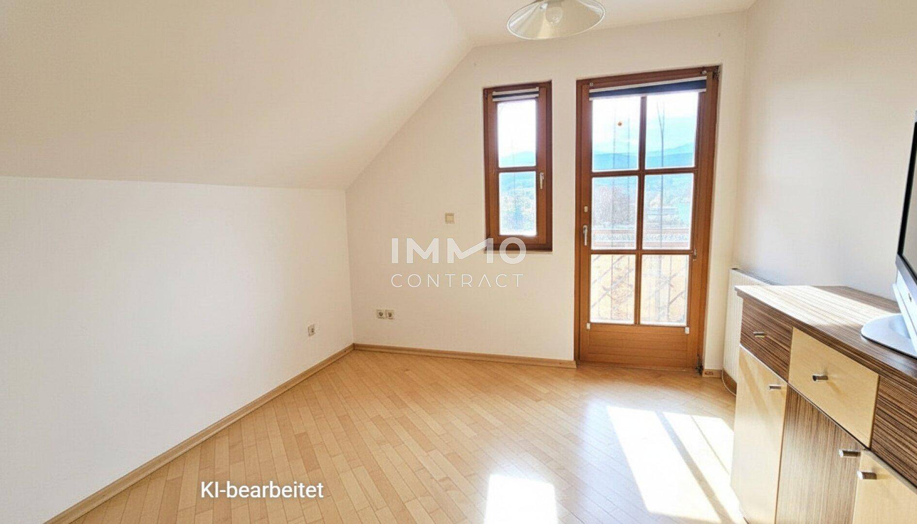 Geräumiges Schlafzimmer im Dachgeschoss mit Dachschrägen, Holzboden und Fenster.