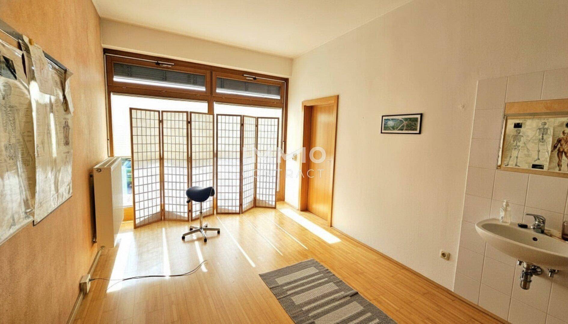 Helles Arbeitszimmer mit großen Fenstern, Holzboden und viel Tageslicht.