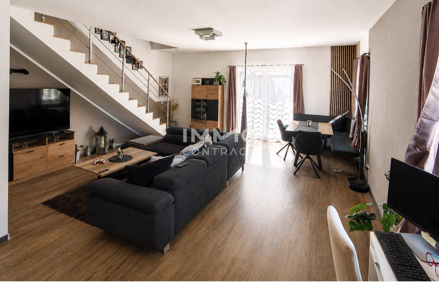 Geräumiger offener Wohn-Essbereich mit Treppe, Sofa und Blick in den Garten.