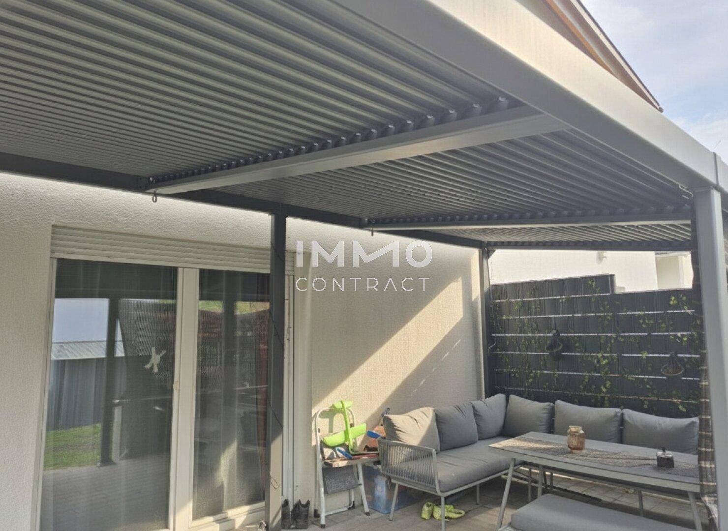 Geräumige überdachte Terrasse mit Zugang zum Haus und Blick in den Garten.
