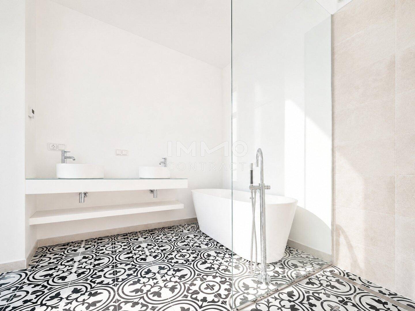 Modernes Badezimmer mit freistehender Badewanne, Doppelwaschbecken und gemusterten Fliesen.