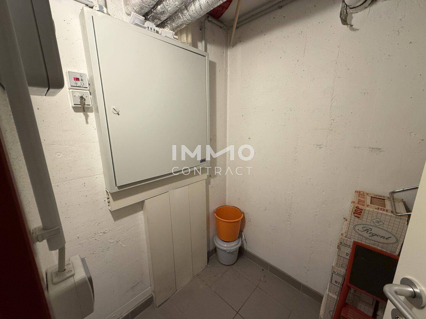 Kellerraum mit Schaltschrank, Rohren an der Decke und Betonwänden.