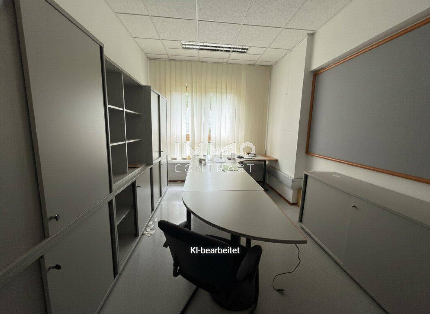 Langes Büro mit Schreibtisch, Bürostühlen und Aktenschränken entlang der Wände.