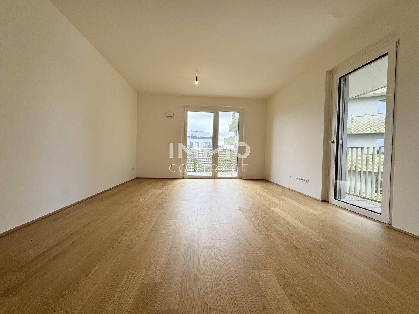 Großer, leerer Raum mit Holzboden und breitem Balkonzugang, ideal für individuelle Gestaltung.
