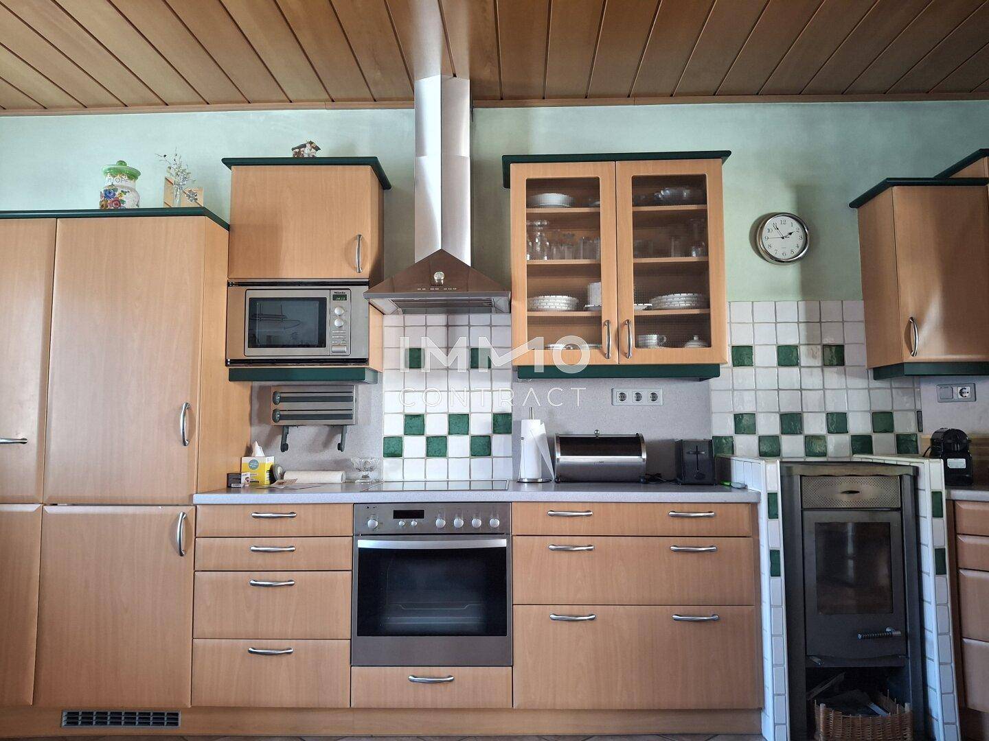 Detailansicht der Küche mit Kochfeld, Backofen und integriertem Mikrowellenherd.