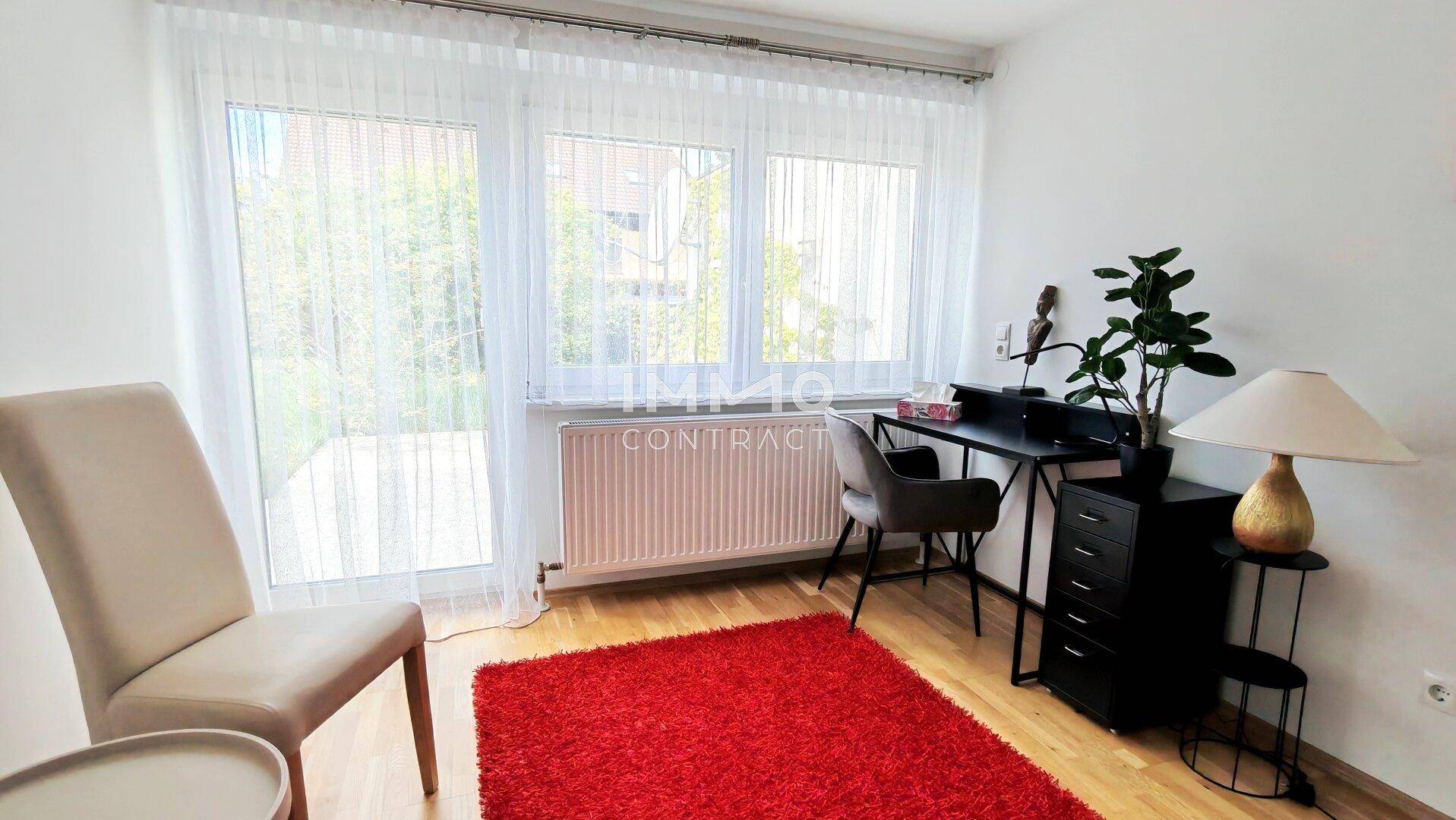 Helles Arbeitszimmer mit Schreibtisch, Stuhl und großen Fenstern für eine inspirierende Atmosphäre.