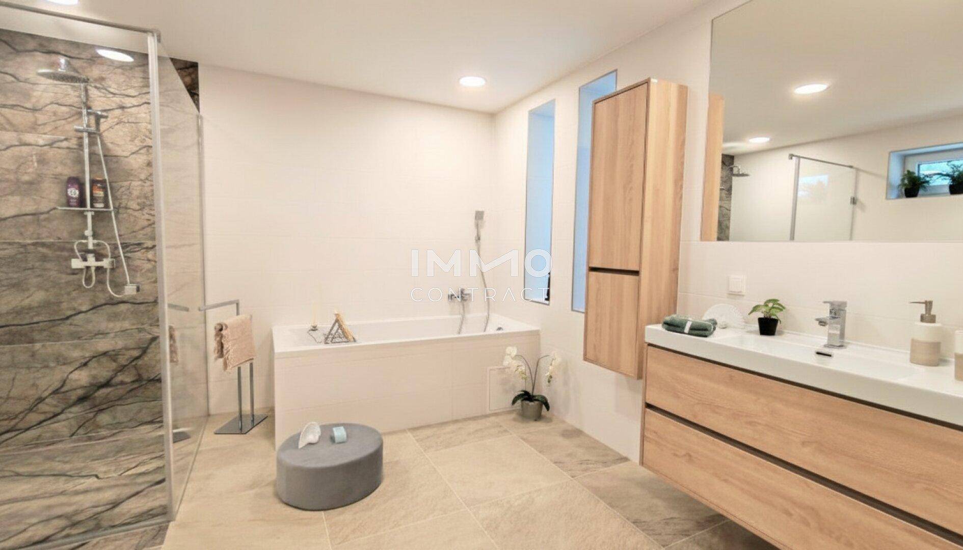 Geräumiges Badezimmer mit Badewanne, separater Dusche und modernem Waschtisch.