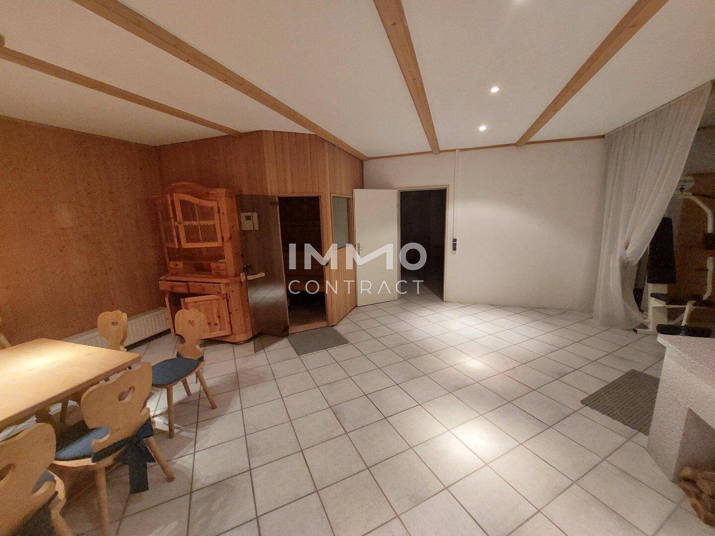 Gemütlicher Wellnessbereich mit Sauna, Holztäfelung und Essbereich.