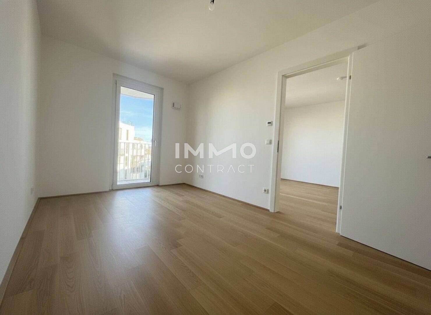 Helles Schlafzimmer mit Parkettboden und direktem Zugang zu einem französischen Balkon.